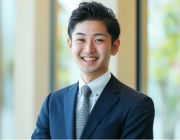 腕を組んだ30代カップルがソファーに座っている様子